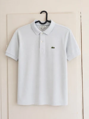 Lacoste piké ljusblå – strl 12 år / 152 cm 🐊 - Klassisk ljusblå pikétröja från Lacoste med den ikoniska krokodilloggan på bröstet. Stilren modell med krage och knappar framtill. 📏 Storlek: 12 år / 152 cm 🩵 Färg: Ljusblå 🐊 Märke: Lacoste ✨ Fint skick, lite missfärgad annars inga defekter! Perfekt till både vardags och lite finare tillfällen. Säljes då den inte längre kommer till användning. Hör gärna av dig vid frågor eller om du vill ha fler bilder! 💌