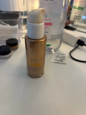 Lumene Natural Glow Foundation - Flytande foundation från Lumene i glasflaska med pump. Ger en naturlig glow och har en varm beige ton. Perfekt för dig som vill ha en fräsch och strålande bas. Flaskan har gulddetaljer och vit pump för enkel applicering. Jag accepterar alla slags bud