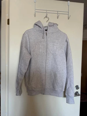 Ljusgrå hoodie Tuttolente - Ljusgrå hoodie med dragkedja och huva. Hoodien har fickor framtill och ribbade muddar. 