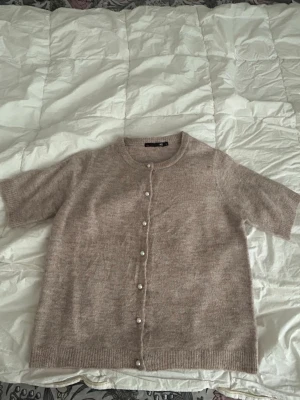 Stickad T-shirt  - En supersöt stickat kortärmad tröja med pärlor som knäppning. Den är knappt använd💕perfekt till hösten 💞💞