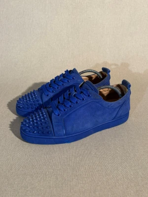 Christian Louboutin Louis Junior  - Storlek: 41 EU = 7/7,5 UK | Färg: Blå | Skick: Bra-Mycket bra skick | Defekter: Lite färg på ytter sulan och slitage. Mockan har små tecken på användning | Material: Mocka | Tillbehör: Äkthets verifikat från Vinted | Pris: 2599kr | Dm för frågor.