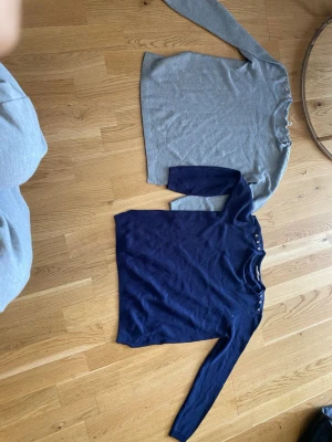 Grå stickad tröja från Esprit - Säljer en stilren grå stickad tröja från Esprit med rund hals och dekorativa knappar vid axeln. Tröjan har lång ärm och är gjord i ett mjukt stickat material som passar perfekt till höst och vinter.