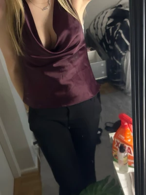 Vinröd satinlinnetopp med drapering - Säljer en vinröd linnetopp i satin med snygg draperad urringning och smala axelband. Toppen har en croppad passform och är perfekt för dig som vill ha en trendig och elegant look. Passar till både jeans och kjol.