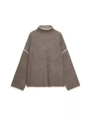 Brun stickad polotröja med kontrastdetaljer - Mysig brun stickad polotröja med vita kontrastsömmar vid ärmar, hals och nederkant. Tröjan har en avslappnad passform och vida ärmar, perfekt för lager på lager under kyliga dagar.