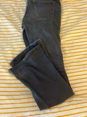 Svarta cheep monday jeans - Säljer ett par svarta jeans med klassisk femficksmodell och bootcut ben. Jeansen har en låg midja och är tillverkade i ett mjukt denimtyg som ger en avslappnad look. Perfekta till en enkel t-shirt eller hoodie. Str 26/32