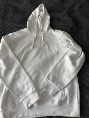 Vit hoodie från Pier One - Snygg vit hoodie från Pier One med klassisk huva och dragsko. Tillverkad i mjukt material och har en stor magficka framtill. Perfekt för en avslappnad och stilren look.