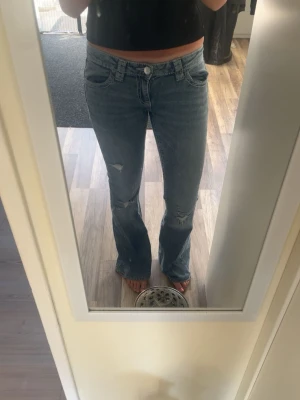Lågmidjade jeans med hål - Säljer ett par ljusblå låga bootcut jeans med hål. Jätte snygga och passar till alla tröjor. 