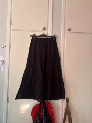 Svart Kjol - Lång flowy svart kjol från gina tricot i storlek S. Lappen har jag klipps bort.