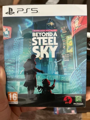 Beyond a Steel Sky PS5 spel - Beyond a Steel Sky till PS5 är ett futuristiskt äventyrsspel med coolt omslag i blåa och neonfärgade toner. Spelet kommer i en klassisk plastfodral och har PEGI 16-märkning. Perfekt för dig som gillar sci-fi och storydrivna spel.