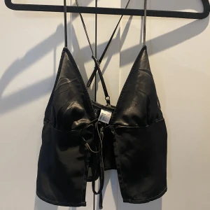 svart satin topp - SÅ fin satin topp!! köpte på hm för ungefär 1 år sen men har använt max 2 gånger då den är väldigt för liten på mig. Den är storlek 36 men passar bättre om du har 32 eller 34. 