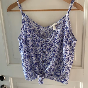 Blå Blommig topp - Topp från H&M. Knappar och Knut framtill.  