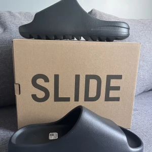 Yeezy slide onyx  - Säljer ett par helt nya yeezy slides i färger onyx, kvitto finns, köpta på adidas CONFIRMED app, 100% äkta