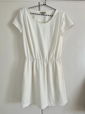 Whyred Klänning Strl 40 - Klänning med axelkuddarna, fickor och resår i midjan. Testad men aldrig använd. Nypris ca 1000 kr