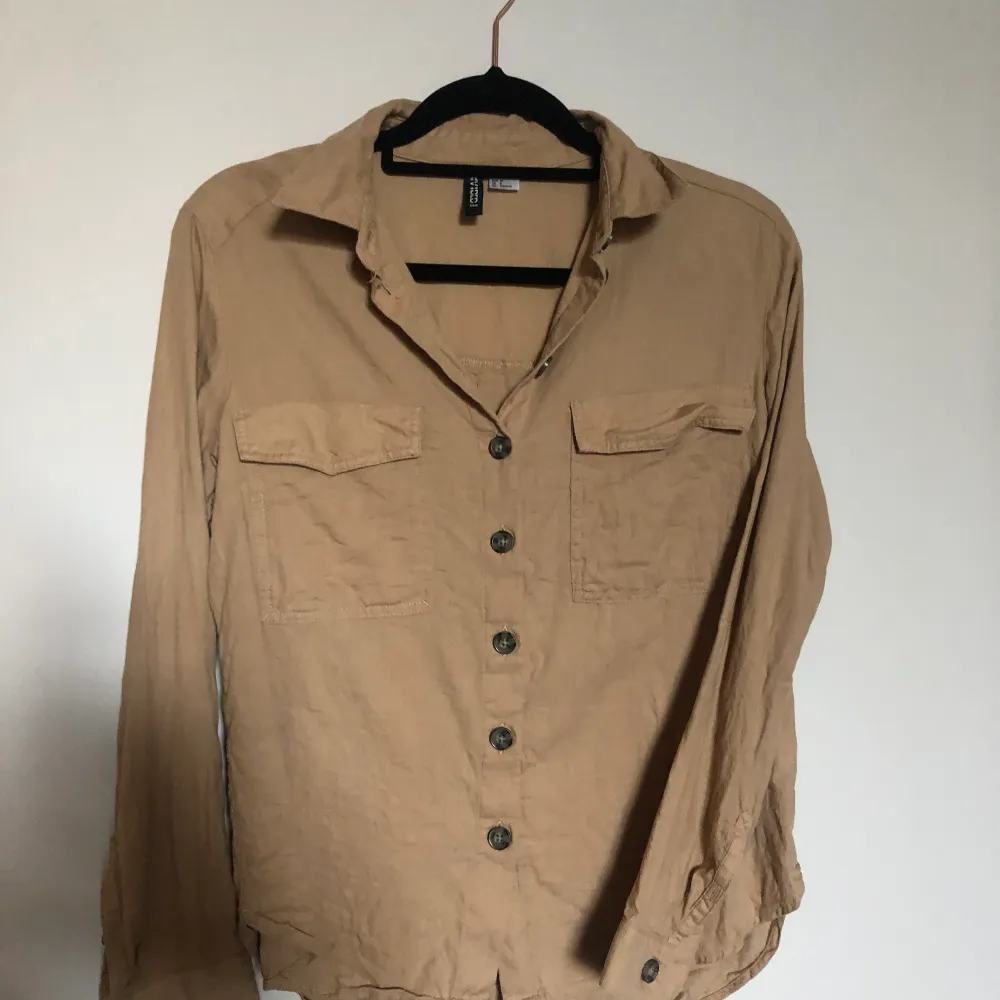 Beige blus/ skjorta från H&M i storlek S/36, nyskick . Blusar.