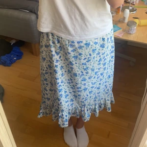 Blå blommig kjol - Jag säljer min kjol för att den inte kommer till användning längre. Den är använd några gånger men jätte bra skick.