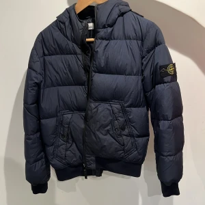 Stone Island Jacka - Stone island junior dunjacka, två små hål, ett i jackan o ett på ryggen (se bild). 164/14 står på storlekslappen