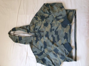 Kamouflage huvtröja - Huvtröja kamouflage mönstrad. Står stl L men jag anser det vara en M. Den är av en kortare modell i midjan.
