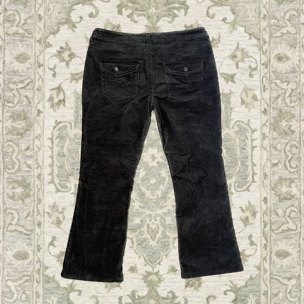 Bootcut svarta byxor med gulliga fickor och knappar med lila detaljer, passar som L och XL. Fin skick 👐. Jeans & Byxor.
