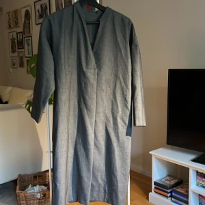 Stilren klänning  - Oanvänd rak och stilren klänning från Filippa K. Lätt v-ringad, fint fall, grafitgrå