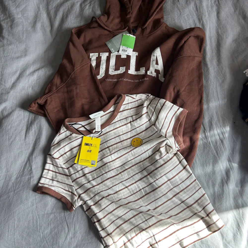 Klädpaket med nya plagg i stl M Byxa och tröja i velour  Crop hoodie blå/vit Crop hoodie brun/vit T-shirt Smile  Stickad kort tröja   På köpet om så önskas: Fluffig kofta/jacka Jacka i fakeskinn (flagnar i kragen)   Katt finns i hemmet. Tröjor & Koftor.