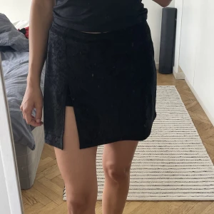 Svart kjol med slits - Fin kortkjol i sammet. Har en slits fram med shorts insydda. 