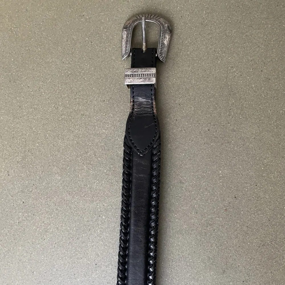 Vintage western-bälte i tjockt svart skinn med metallspänne. Bredd: 3,4cm Längd: 91 cm (mätt från spänne till yttersta hålet). Accessoarer.
