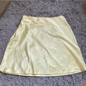 Ljusgul satinkjol - Supersöt gul satinkjol från Chiquelle. Som ny, säljes då den tyvärr är lite för stor på mig! 🌼