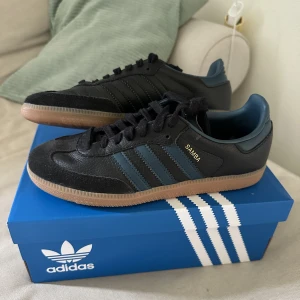 Adidas Samba - Adidas Samba OG Core Black-Arctic Night-Gum 3 i storlek 38. Köpt väldigt nyligen och endast använda 2 gånger så i nyskick! Då jag har både svarta och vita tror jag inte att dessa kommer komma till så mycket använding. Prisförslag är välkomna!
