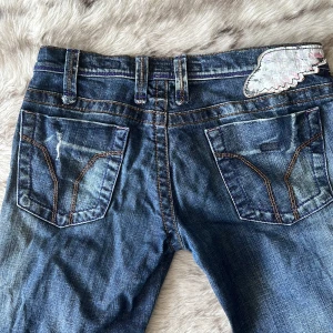Miss Sixty jeans  - Distressed Miss Sixty jeans i superfin midell (j lot) med dragkedjor vid anklarna. En söm vid dragkedjan har gått upp (därav det superlåga priset) i övrigt är byxorna i kanonskick!  Storlek 29