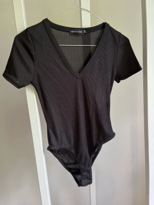 Svart T-shirt body - Aldrig använd, bara testad 