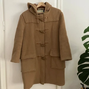 Duffel Gloverall  - Klassisk duffel från brittiska gloverall. Bra skick, i 70% ull, varm. Kostar ca 4000 ny. Passar 34-40. Bild 1 återger färgen bäst. 