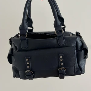 Mörkblå väska - En super snygg mörkblå väska med nitar! Köpt för 350kr och är nästintill oanvänd!❤️(mycket rymlig och det långa bandet ingår såklart!)