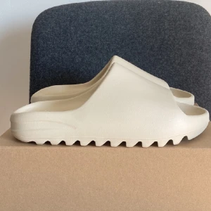 Yeezy slide ”bone” storlek 46 - Yeezy slide ”bone” Storlek 46 Aldrig använda! Kan mötas upp i Gbg eller frakta! Köpta från adidas CONFIRMED så dem är 100% äkta!! Bara att skriva vid minsta fråga! Dem är lite små för sin storlek alltså passar dem 44 och 45 bäst 