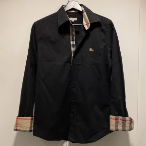 Burberry Oxford Monogram Skjorta - Hej, säljer den populära Burberry skjortan med det ikoniska mönstret på ärmar & krage. Nypris 5400kr. Bra skick, sparsamt använd. Äldre modell med bröstloggan i guld och mindre passform. Storlek M men passar S/XS. Pris kan diskuteras. Hör av dig! 