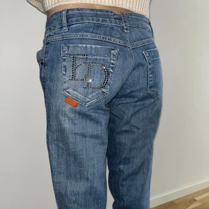lågmidjade jeans med rhinestones - ascoola blåa low rise jeans med paljetter på bakfickorna som står ”ED” på vänster sida. Det är en straight modell. Säljer eftersom de inte passar mig :( Pris går att diskuteras🙏 modellen (syrran) är 164cm lång