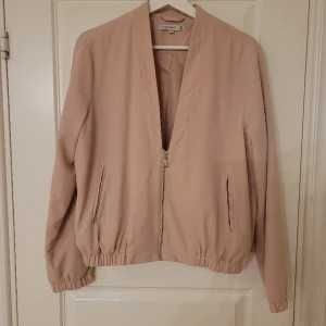 Rosa sommarjacka - Rosa sommarjacka, perfekt till ljumma sommarkvällar. Normal storlek, materialet är polyester och elasten.