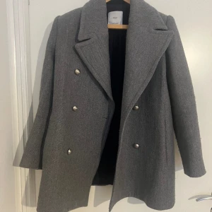 Grå kappa från Mango - Grå kort kappa från Mango. Väldigt varm använt några gånger helt okej skick. 