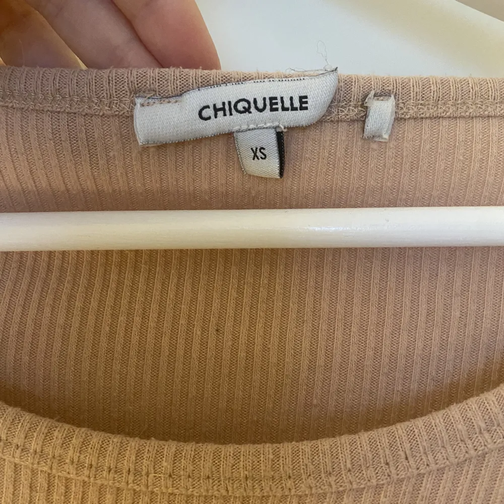 Persikofärgad stretchig långärmad tröja med utsvängda ärmar från chiquelle. Köpt för några år sedan, inga defekter förutom lappen i tröjan har lossnat på ena sidan, syns på bild två.. Tröjor & Koftor.