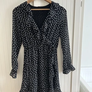 prickig volangklänning - Jättefin kort klänning med volanger och resår i midjan! Supersöt men har klippt av taggen så vet ej storlek eller var den kommer ifrån. Skulle estimera en strl 36! 