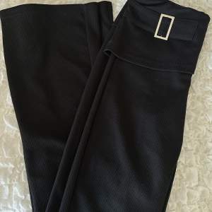 Svarta utsvängda byxor med nedvikt kant och silver detalj. Nyskick storlek small