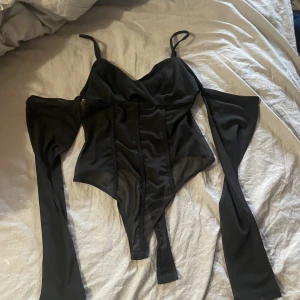Body - En fin svart body, med ärmar. Aldrig använd. 