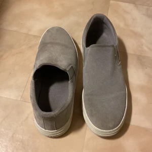 Selected/Homme slip on skor. - Tjena! Säljer ett par slip on skor från Selected/Homme. Använda ett fåtal gånger men finns inga tydliga defekter men finns några väck. Ny pris 800kr. Bara att skriva om ni har frågor eller om det önskas fler bilder. Mvh Jagger 😇