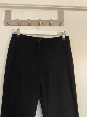Vida svarta kostymbyxor  - Stretchiga kostymbyxor med vida ben och medel hög midja. Har tecken på användning men i bra skick