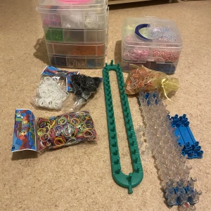 Loomband med tillbehör - Säljer Loomband med tillbehör. Två förvaringslådor fyllda med band. Två oöppnade påsar med band. Krokar och allt möjligt finns med. 