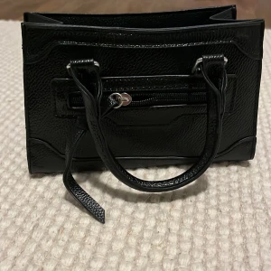 Väska  - Liten gullig handväska med band till. Perfekt när man bara vill ha en liten för telefon o nycklar till ex fest! 