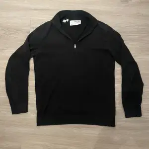 Svart stickad Halfzip från selected homme i storlek S, skicket är 8/10 då den har ett litet hål på kragen där bak (bild 3) hör av er för mer info!