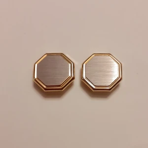 Knappsmycke - Knappsmycke i silver med guldduble. Fint och i nyskick. 1,5 cm bred 