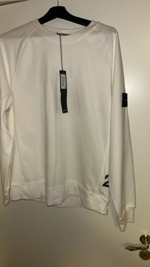 stone island sweatshirt  - helt ny stone island säljes  de e text i mitten av den och nere på sidan så ingen vanlig vit sweetshirt.