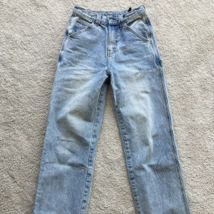 Ljusa baggy jeans - Snygga jeans som är köpta här på plick. De är slitna längst ner men annars i fint skick. Midjemått: ca 75 cm(går att justera lite) Innerbensläng: 89 cm Hör av dig om du har frågor!