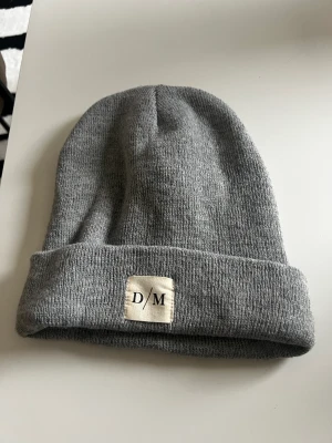 Grå mössa - En fin grå mössa ifrån Lager 157. Det är one size och den är bekväm och varm. Använd nägra gånger men inga synliga skador eller liknande, dock har märket blivit lite ”brunt”❤️ 100%Acrylic